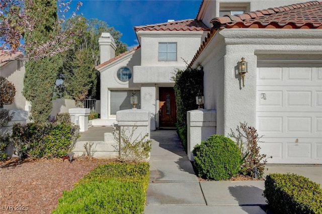 exterior space featuring a garage, a tiled roof, and stucco siding