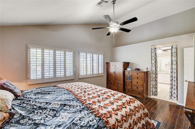 bedroom featuring ceiling fan, ensuite bathroom, wood finished floors, visible vents, and vaulted ceiling