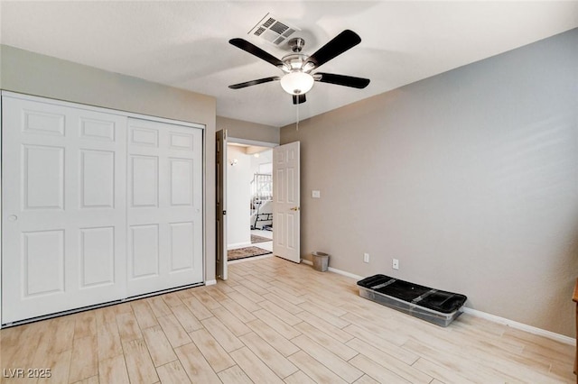 unfurnished bedroom featuring ceiling fan, visible vents, baseboards, a closet, and light wood-type flooring