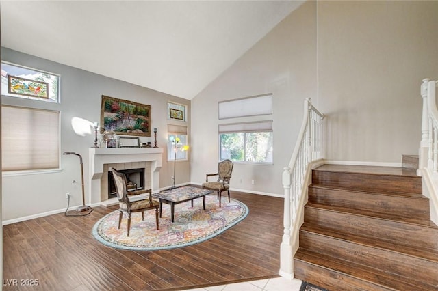 interior space featuring stairway, a tiled fireplace, and wood finished floors