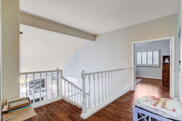 corridor with vaulted ceiling with beams, wood finished floors, an upstairs landing, and a chandelier