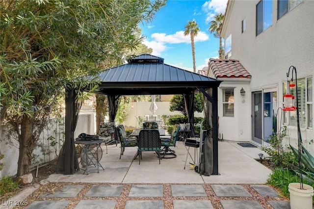 view of patio / terrace featuring outdoor dining space, fence, and a gazebo