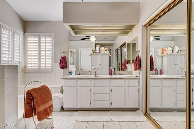 bathroom with a bath, double vanity, tile patterned flooring, and a ceiling fan