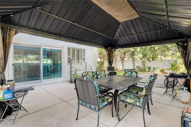 view of patio / terrace featuring outdoor dining area, fence, and a gazebo