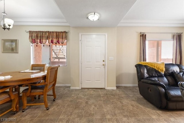 dining space with a tray ceiling and baseboards