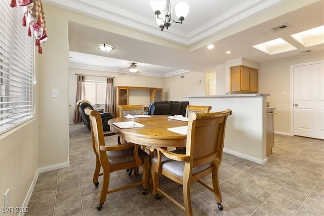 dining room with baseboards, ceiling fan with notable chandelier, visible vents, and ornamental molding