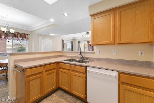 kitchen featuring dishwasher, a peninsula, light countertops, a sink, and recessed lighting