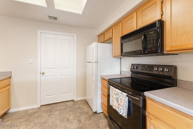 kitchen featuring light countertops, visible vents, light brown cabinetry, black appliances, and baseboards