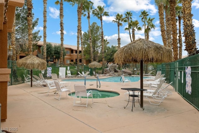 pool with a patio area and fence