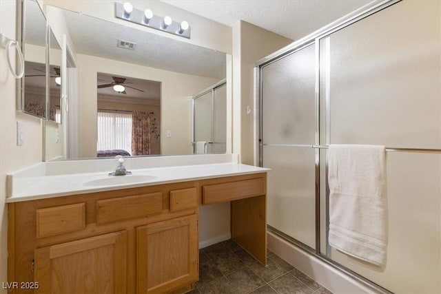 bathroom with visible vents, a ceiling fan, a shower stall, vanity, and tile patterned flooring