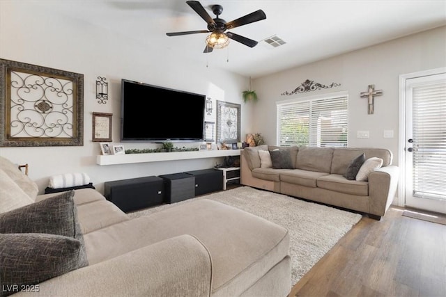 living area with ceiling fan, visible vents, and wood finished floors