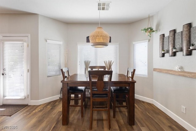 dining room with visible vents, baseboards, and wood finished floors