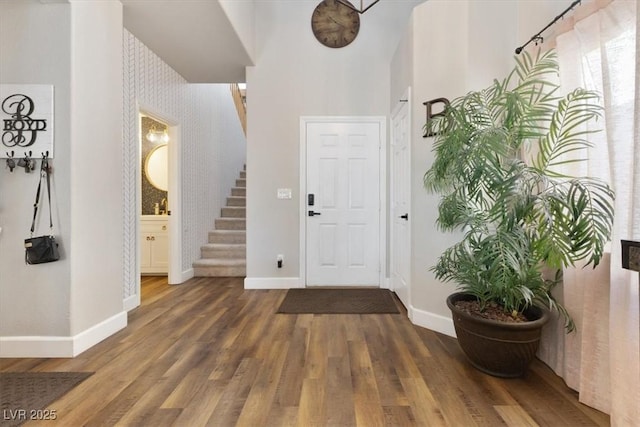 entrance foyer with stairs, baseboards, and wood finished floors