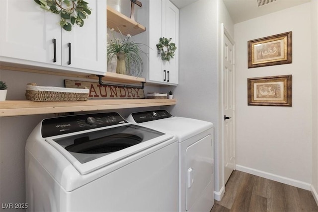 washroom featuring dark wood-style floors, cabinet space, baseboards, and separate washer and dryer