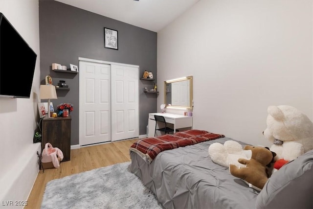 bedroom with a closet, wood finished floors, and baseboards