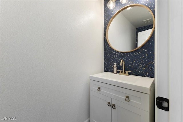 bathroom featuring wallpapered walls, visible vents, and vanity