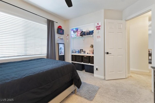 bedroom featuring baseboards, a ceiling fan, and light colored carpet