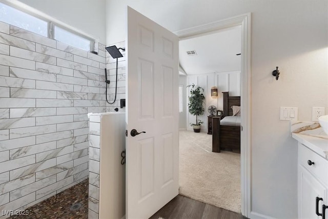 ensuite bathroom with a walk in shower, plenty of natural light, and visible vents