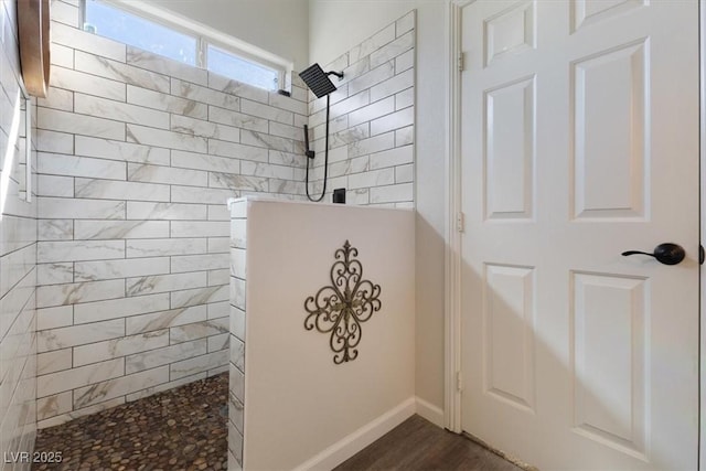 full bath featuring baseboards, walk in shower, and wood finished floors