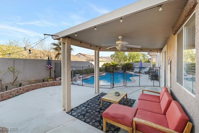 view of patio featuring a pool with connected hot tub, a fenced backyard, and a ceiling fan