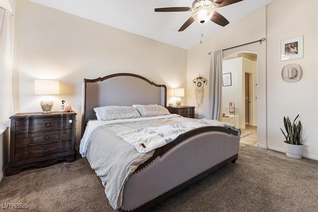 carpeted bedroom with arched walkways, a ceiling fan, and baseboards