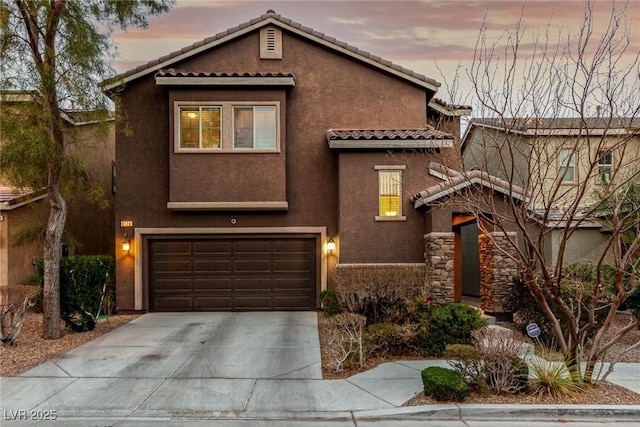 mediterranean / spanish-style house with concrete driveway, a tile roof, and stucco siding