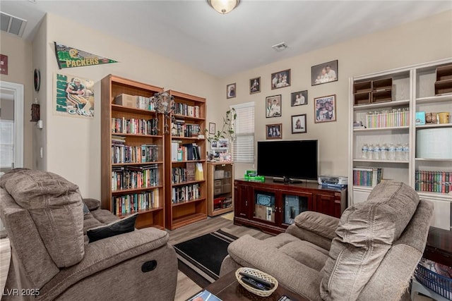 living area with visible vents and wood finished floors