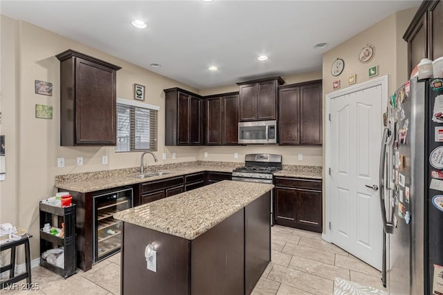 kitchen with wine cooler, stainless steel appliances, a sink, a kitchen island, and dark brown cabinets