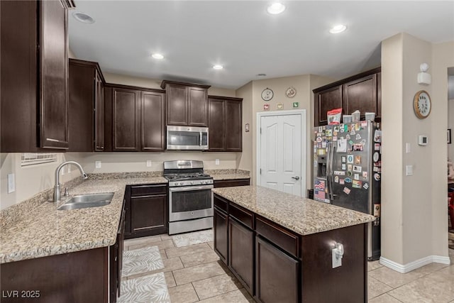 kitchen with dark brown cabinetry, recessed lighting, a kitchen island, a sink, and appliances with stainless steel finishes