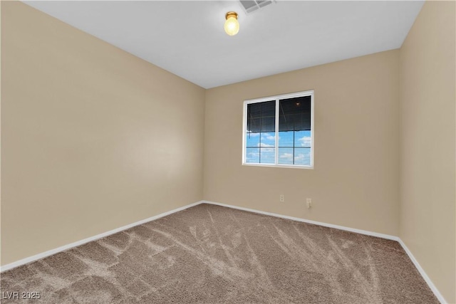 spare room with carpet floors, visible vents, and baseboards