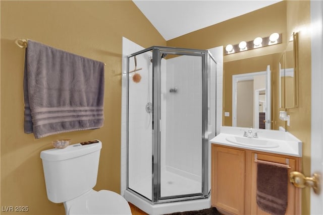 bathroom with toilet, a stall shower, vaulted ceiling, and vanity