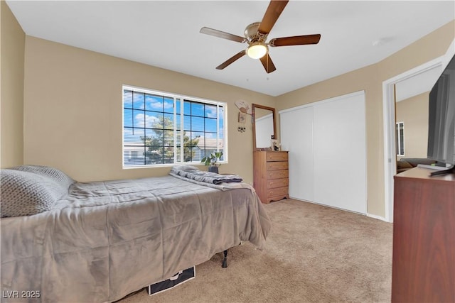 bedroom featuring light carpet, a ceiling fan, and a closet