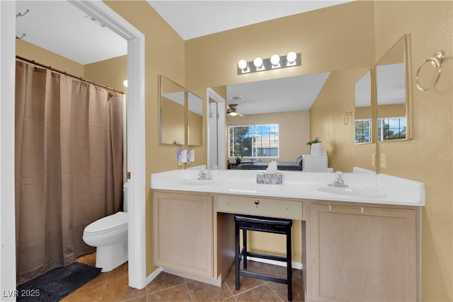 bathroom featuring double vanity, a sink, toilet, and tile patterned floors