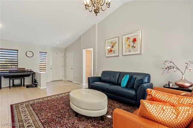 living area with light wood finished floors, baseboards, a chandelier, and high vaulted ceiling