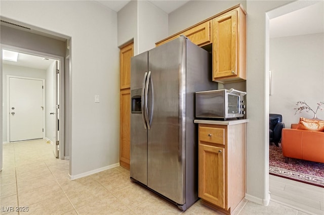 kitchen with baseboards, light tile patterned floors, and stainless steel fridge with ice dispenser