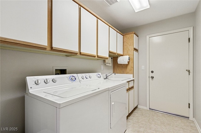 clothes washing area featuring a sink, visible vents, baseboards, independent washer and dryer, and cabinet space