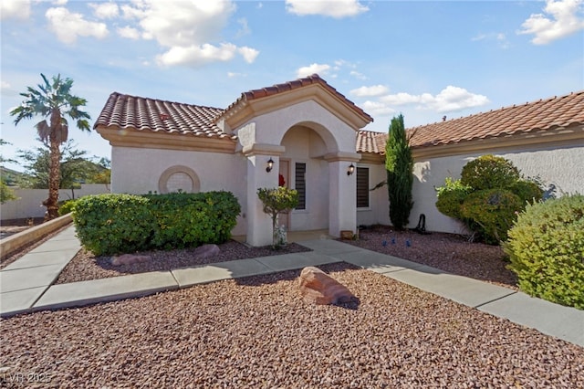 mediterranean / spanish home with a tile roof and stucco siding