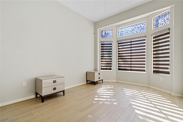 empty room featuring light wood-type flooring and baseboards