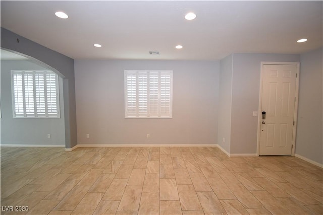 empty room with light wood-style floors, baseboards, visible vents, and recessed lighting