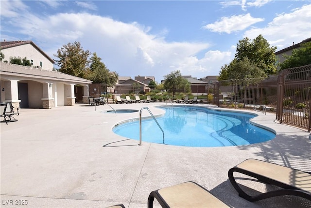 community pool with a community hot tub, a patio area, and fence