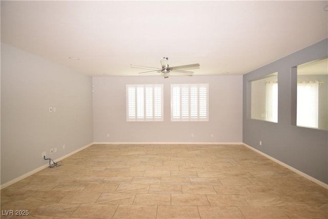 unfurnished room featuring ceiling fan and baseboards