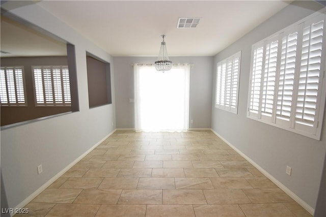 spare room featuring an inviting chandelier, baseboards, light tile patterned floors, and visible vents