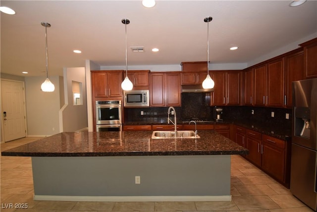 kitchen with tasteful backsplash, visible vents, appliances with stainless steel finishes, under cabinet range hood, and a sink