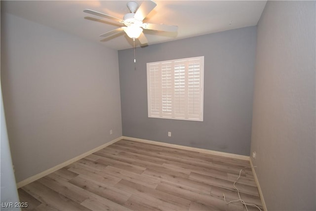 empty room featuring a ceiling fan, baseboards, and wood finished floors