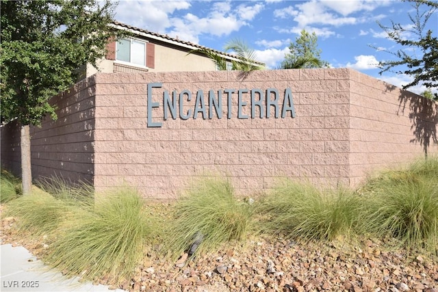 community / neighborhood sign featuring fence