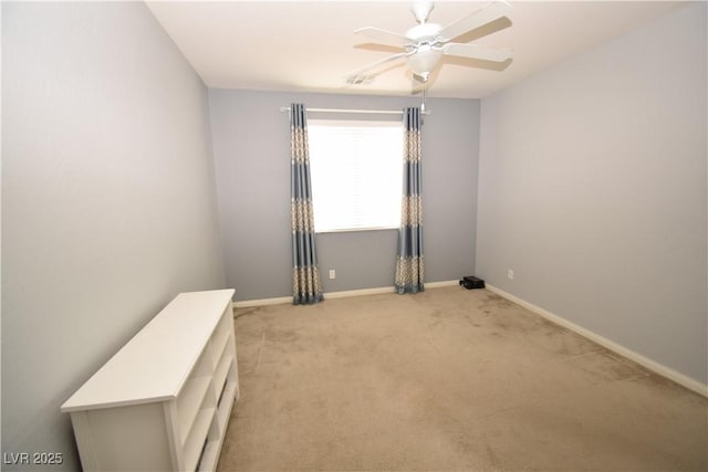 spare room with light carpet, ceiling fan, visible vents, and baseboards