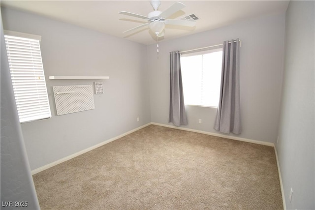 spare room with a ceiling fan, carpet, visible vents, and baseboards