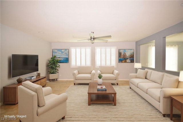 living area with a ceiling fan and baseboards