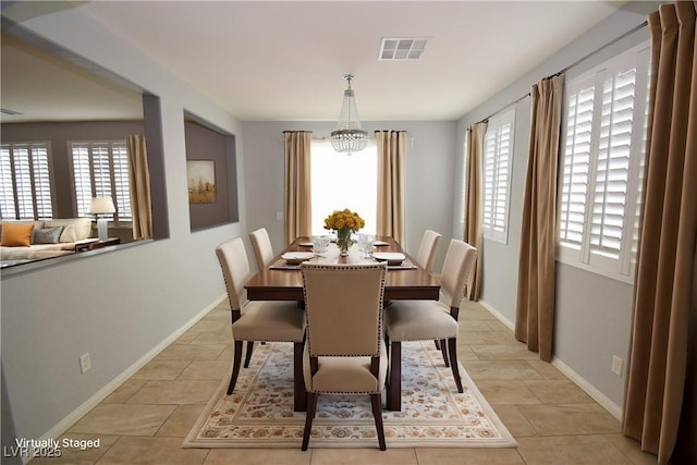 dining room featuring light tile patterned floors, visible vents, and baseboards
