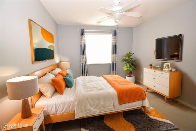 carpeted bedroom with a ceiling fan and baseboards